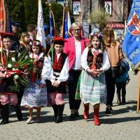 Miechowskie obchody 231. rocznicy uchwalenia Konstytucji 3 Maja - uczniowie w strojach krakowskich z wiązanką kwiatów