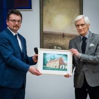 Przewodniczący Rady Muzealnej Ryszard Nasada wręcza pamiątkową grafikę Marcinowi Florkowki, Dyrektorowi MZM